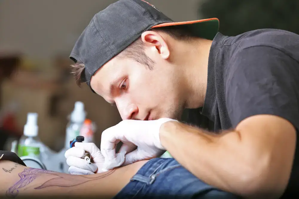 man tattooing dove