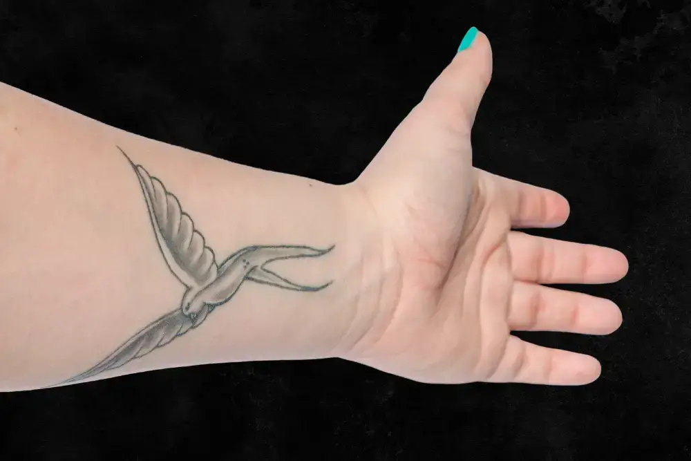 Woman's hand with dove tattoo