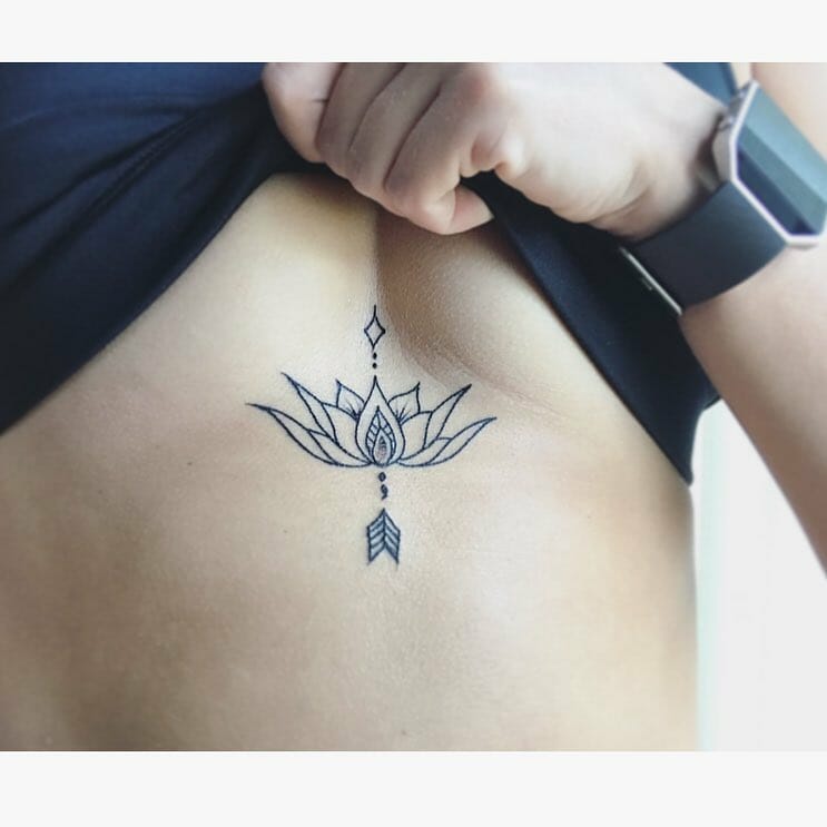 Outlined lotus flower and arrow tattoo design